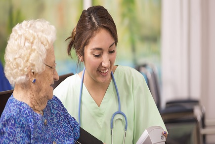 Latin descent female nurse or doctor checks blood pressure of a senior woman patient.  Home or clinic setting.  Woman is over 100 years old!